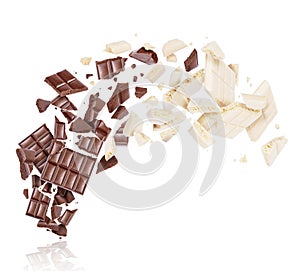 Porous dark and milk chocolate broken into many pieces in the air