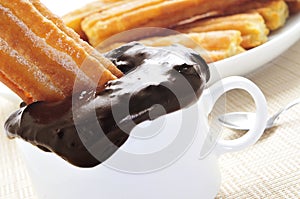 Porras, thick churros typical of Spain, dipped in hot chocolate photo