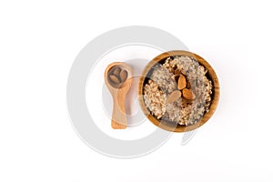 Porridge, Cinnamon and Almonds and in the Spoon on top in a wooden bowl and wooden spoon isolated on white background