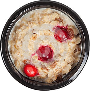 Porridge in disposable round plastic black bowl top view on white background