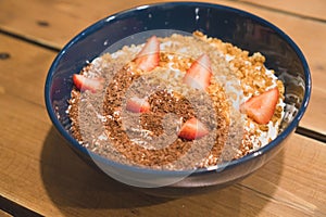 Porridge - healthy breakfast for children and adults. Breakfast cereal with strawberries and chocolate for breakfast in a blue cup