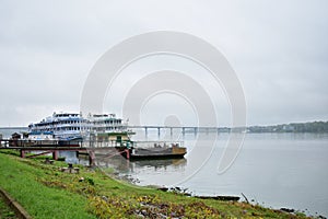 Port berth on the river cruise ships embankment, bridge automobile, fog over