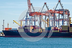 Port cargo crane loads a container onto a cargo ship in a seaport