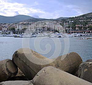 The port with the concrete boulders as breakwater in the foreground.