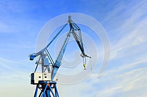 Port crane against a blue sky with a light cloud cover