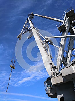 Port crane silhouette against deep blue sky