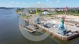 A port crane unloads a barge. River port, dredging works. Aerial photography.