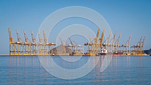 Port cranes loading container ship in the Port of Fujairah, United Arab Emirates.