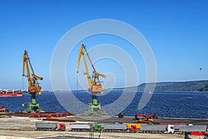 Port cranes ready to load containers from cargo ships.