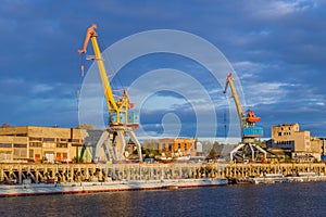 Port cranes on sunset