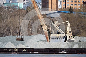 Port cranes unload crushed stone photo