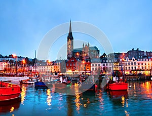 Port, houses, restaurants, shops, bars, pubs and Cathedral at night in Cobh, Ireland