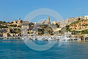 The port of M?arr on the island of Gozo, Malta. Beautiful city on the cliffs and hills on the background.