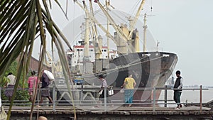 PORT, QUAY & JETTY: ASIA - Porters carry sacks across a gangway near ship