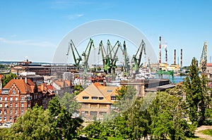 Port with ships, ferries, cranes. Cranes for loading, unloading various cargoes and containers. Port of Gdansk. Barges in docks of
