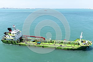 Port of Singapore, bunker barge supplying fuel to cargo ship.