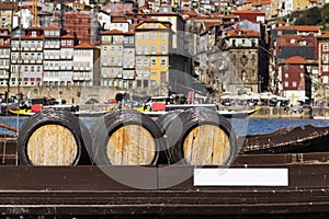 Port Wine barrels in a boat in the Douro River with the city of Porto in the background