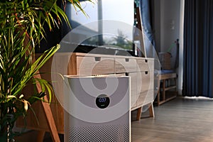 Portable air purifier on wooden floor in comfortable home for improve air quality and healthy life.