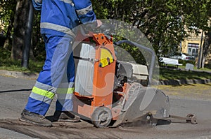 Portable asphalt cutter close-up, cuts asphalt with a diamond blade to repair part of the roadway.