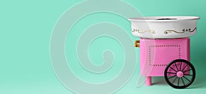 Portable candy cotton machine on turquoise background. Banner design with space for text