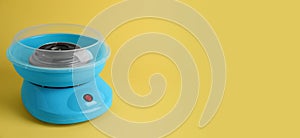 Portable candy cotton machine on yellow background. Banner design with space for text