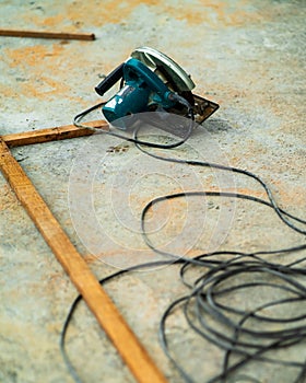 Portable circular saw tool with long wires to cut wood in a construction site