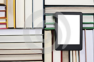 Portable e-book reader on different hardcover books, top view