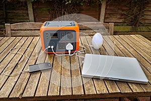 Portable electric power station solar electricity generator with laptop, cell phone, lamp charging.