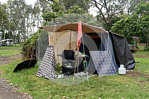 Portable foldable solar panels and Tent at the campsite surrounding by nature. Camping and recreation
