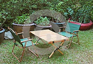 Portable Folding Chairs and a Wooden Table in the garden