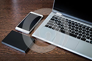 A portable hdd connected to a laptop with usb flash drive and smartphones