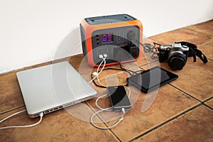 Portable power station solar electricity generator with laptop, phone, tablet and camera charging.