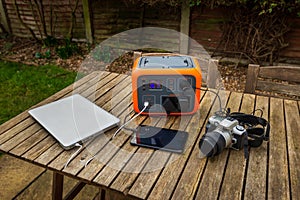Portable power station solar electricity generator with laptop, tablet and camera charging.