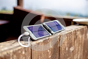 Portable solar panel charges the battery of a powerbank.