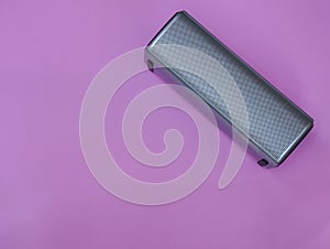 Portable speaker on pink pastel background for music listening