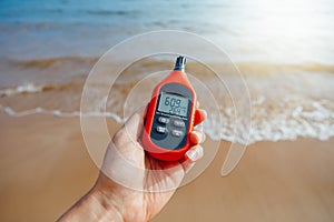 Portable thermometer in hand measuring outdoor air temperature and humidity