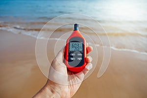 Portable thermometer in hand measuring outdoor air temperature and humidity