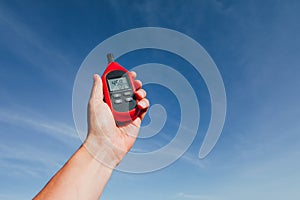 Portable thermometer in hand measuring outdoor air temperature and humidity