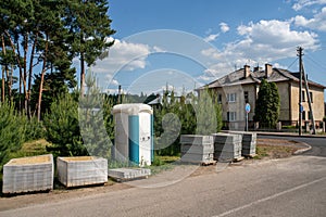 Portable toilet and building materials on the street