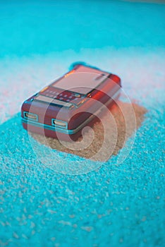 Portable vintage transistor lying on white carpet.