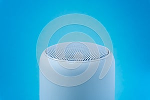 Portable wireless speaker on blue gradient background