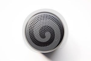 Portable Wireless Speaker Isolated on White Background; Top View Showing Dotted Black Metal Grille Holes