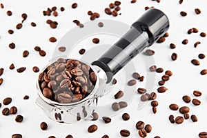Portafilter filled and surrounded with whole coffee beans isolated on white background.