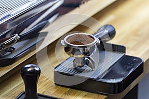 Portafilter with freshly ground morning coffee on the scales photo