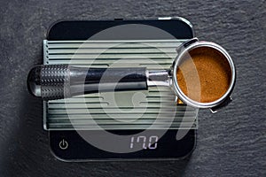 Portafilter on the scales with freshly ground morning coffee on