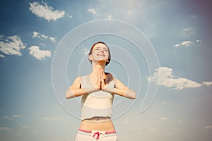 Portait of beautiful young woman doing joga on the wonderful sky