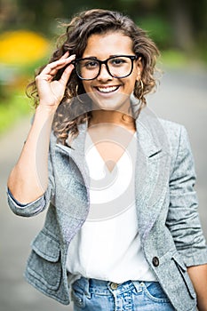 Portait of business woman in eyesglasses walking outdoor