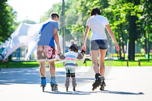 Cute baby boy and his mom learning inline skating