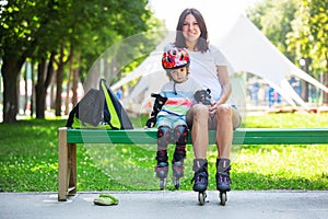 Portait of cute baby boy and his mom wearing inline skates