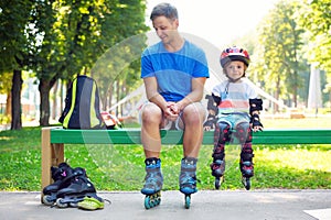 Portait of cute baby boy with inline skating instructor.